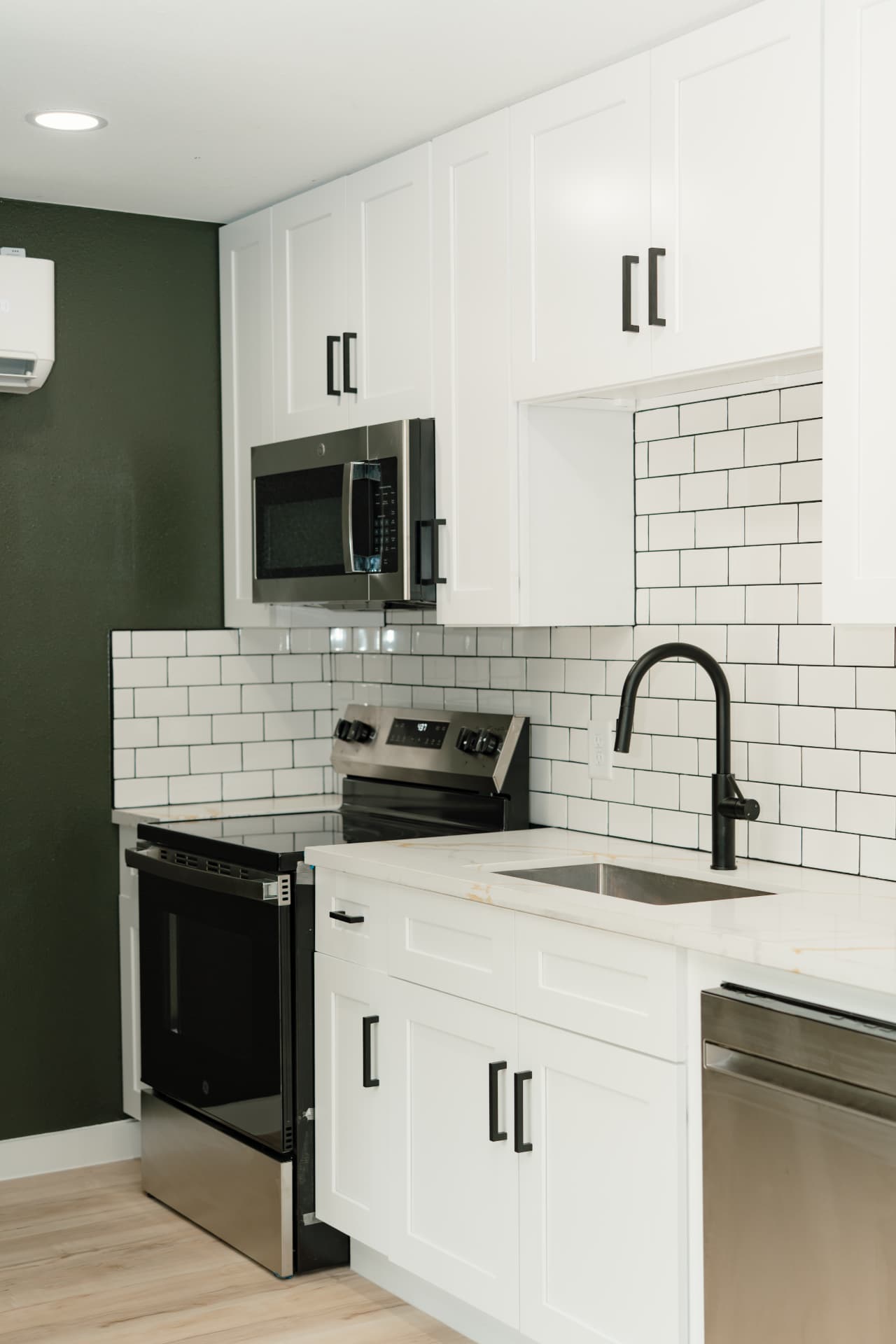 Kitchen with quartz counters, subway tile and matte black fixtures